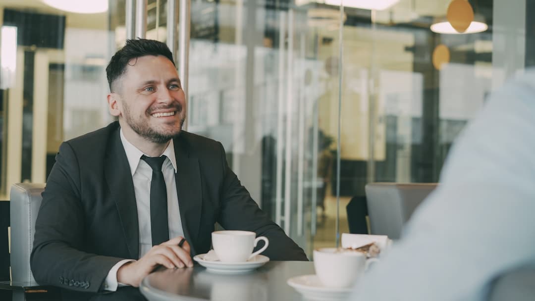 Deux collègues souriants discutant autour d'un café en entreprise